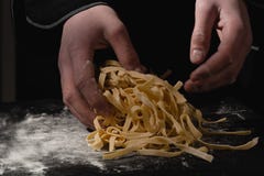 Chef hands making spaghetti, pasta, noodles with fresh pasta on black table with royalty free stock photos Chef hands making spaghetti, pasta, noodles with fresh pasta on black table with royalty free stock photos