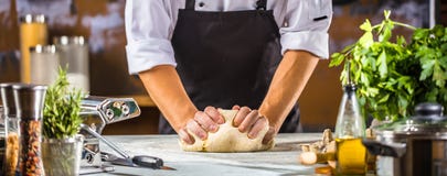 Chef-kok die deeg voor pizza of deegwaren in de restaurantkeuken voorbereiden stock afbeeldingen Chef-kok die deeg voor pizza of deegwaren in de restaurantkeuken voorbereiden stock afbeeldingen