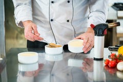 Chef or Patissier preparing a creme brulee stock photos Chef or Patissier preparing a creme brulee stock photos