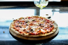 Chef is putting sesame oil to topping of pizza. It has nice smell or good smell. He cook at kitchen. It looks so tasty. The royalty free stock photo Chef is putting sesame oil to topping of pizza. It has nice smell or good smell. He cook at kitchen. It looks so tasty. The royalty free stock photo