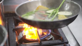 Chef`s hands cooking fresh vegetables in frying pan