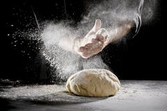 Chef scattering flour while kneading dough