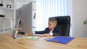 Chefe e secretário pequenos O rapaz pequeno alegre no terno der ordens quando menina no formalwear que está perto dele fotos de stock royalty free Chefe e secretário pequenos O rapaz pequeno alegre no terno der ordens quando menina no formalwear que está perto dele fotos de stock royalty free