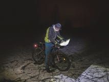 Chemin perdu de cycliste en congère de nuit Homme avec le mtb image stock Chemin perdu de cycliste en congère de nuit Homme avec le mtb image stock