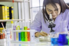 Chemist woman using microscope, chemical testing in lab, concept for improving safety products before applying to consumers royalty free stock image Chemist woman using microscope, chemical testing in lab, concept for improving safety products before applying to consumers royalty free stock image