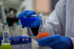 Chercheur ou scientifique ou étudiant de phd mélangeant le ch bleu et orange images libres de droits Chercheur ou scientifique ou étudiant de phd mélangeant le ch bleu et orange images libres de droits