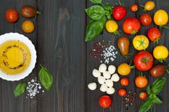 Cherry tomatoes, mozzarella, basil leaves, spices and olive oil from above. Italian caprese salad recipe ingredients Stock Photo Cherry tomatoes, mozzarella, basil leaves, spices and olive oil from above. Italian caprese salad recipe ingredients Stock Photo