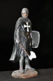 Chevalier de chiffre de jouet avec une hache et un bouclier sur un fond noir photo stock Chevalier de chiffre de jouet avec une hache et un bouclier sur un fond noir photo stock