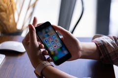 CHIANG MAI THAILAND - Juni 30,2018: Kvinna som rymmer Apple iPhone 6S Rose Gold med symboler av socialt massmedia på skärmen saml arkivfoto CHIANG MAI THAILAND - Juni 30,2018: Kvinna som rymmer Apple iPhone 6S Rose Gold med symboler av socialt massmedia på skärmen saml arkivfoto