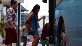 CHIANGMAI, THAILAND-MAY 6,2019: Mama i dziecko przy przystankiem autobusowym, czekać na autobus zbiory CHIANGMAI, THAILAND-MAY 6,2019: Mama i dziecko przy przystankiem autobusowym, czekać na autobus zbiory