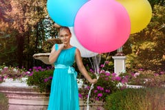 Chica joven bonita con los globos coloridos grandes que camina en el parque cerca de la ciudad - imagen imagen de archivo libre de regalías Chica joven bonita con los globos coloridos grandes que camina en el parque cerca de la ciudad - imagen imagen de archivo libre de regalías