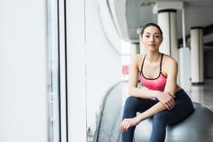 Chica joven hermosa con la bola del ajuste La mujer de la aptitud que se resuelve con la bola de los pilates, se relaja y descans fotografía de archivo libre de regalías Chica joven hermosa con la bola del ajuste La mujer de la aptitud que se resuelve con la bola de los pilates, se relaja y descans fotografía de archivo libre de regalías