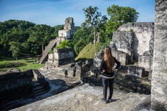 Chica joven que comtempla ruinas mayas en Tikal, parque nacional Tr Fotografía de archivo libre de regalías Chica joven que comtempla ruinas mayas en Tikal, parque nacional Tr Fotografía de archivo libre de regalías