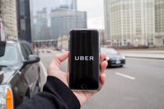 Chicago, IL die, de V.S., februari-21.2017, Mens een smartphone met open Uber app in de stad voor redactie slechts gebruik houden stock foto Chicago, IL die, de V.S., februari-21.2017, Mens een smartphone met open Uber app in de stad voor redactie slechts gebruik houden stock foto