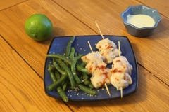 Chicken skewers with dipping sauce and green beans Stock Image Chicken skewers with dipping sauce and green beans Stock Image