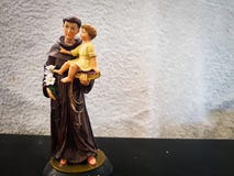 Chiffre de jouet de St Anthony tenant un enfant de garçon photo stock Chiffre de jouet de St Anthony tenant un enfant de garçon photo stock