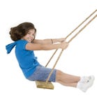 Cute Caucasian child playing on a wooden swing