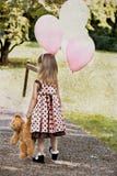 Child Carrying Balloons And Dragging Her Teddy Royalty Free Stock Photography Child Carrying Balloons And Dragging Her Teddy Royalty Free Stock Photography