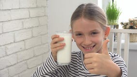 Child Drinking Milk at Breakfast in Kitchen, Girl Tasting Dairy Products royalty free stock photography Child Drinking Milk at Breakfast in Kitchen, Girl Tasting Dairy Products royalty free stock photography