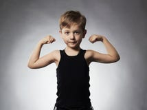 Child. Funny Little Boy.Sport Handsome Boy showing his hand biceps muscles Stock Photo Child. Funny Little Boy.Sport Handsome Boy showing his hand biceps muscles Stock Photo