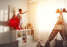 Child girl in a super hero costume with mask and red cloak stock photo Child girl in a super hero costume with mask and red cloak stock photo