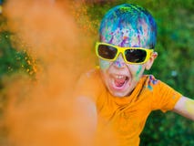The child in glasses throws paint holi stock photo The child in glasses throws paint holi stock photo