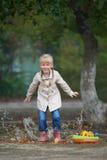 A child jumping in the puddle just after rain