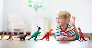 Child playing with toy dinosaurs. Kids toys