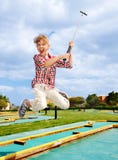 Child playing golf in park.