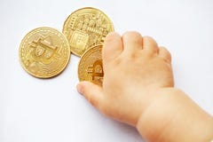 The child pulls hands to Bitcoin cryptocurrency coins. The future is decentralized systems. Close-up stock photography The child pulls hands to Bitcoin cryptocurrency coins. The future is decentralized systems. Close-up stock photography