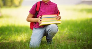Child with rucksack sitting in the park near school royalty free stock photography Child with rucksack sitting in the park near school royalty free stock photography