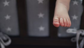 The child is sleeping in bed, his leg is hanging down. leg of a little sleeping baby. royalty free stock photos The child is sleeping in bed, his leg is hanging down. leg of a little sleeping baby. royalty free stock photos