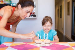 Child smiling watching woman lighting candles on birthday cake Stock Images Child smiling watching woman lighting candles on birthday cake Stock Images