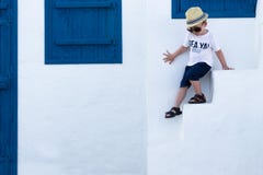 Cheerful Boy on the Background of the White-Blue Building. The Greek Concept stock photo Cheerful Boy on the Background of the White-Blue Building. The Greek Concept stock photo