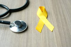 Childhood Cancer Awareness, Yellow Ribbon with stethoscope for supporting people living royalty free stock image Childhood Cancer Awareness, Yellow Ribbon with stethoscope for supporting people living royalty free stock image