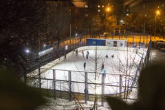 Children and adults skate at the ice rink on a winter evening royalty free stock photo Children and adults skate at the ice rink on a winter evening royalty free stock photo