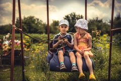 Children boy and girl swinging together in summer day on backyard in countryside concept happy chilhood stock images Children boy and girl swinging together in summer day on backyard in countryside concept happy chilhood stock images