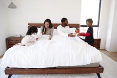 Children Bringing Parents Breakfast In Bed To Celebrate Mothers Day Fathers Day Or Birthday stock images Children Bringing Parents Breakfast In Bed To Celebrate Mothers Day Fathers Day Or Birthday stock images