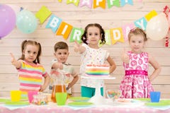 Children celebrating birthday party. Happy kids show thumbs up