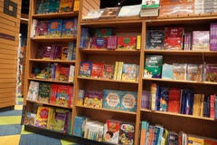 Children drawing and coloring books on shelves in a bookstore for sale. Library kids books section. Variety of Books For Sale On