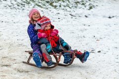 Children Enjoy Snowshoeing In The Snow Park Where The Grass Comes Out Stock Image