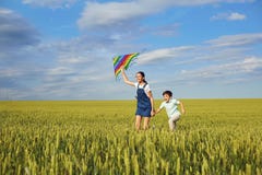 Children with a kite run across the wheat field in the summer. C royalty free stock images Children with a kite run across the wheat field in the summer. C royalty free stock images