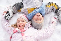 Children Laying On Ground Making Snow Angel