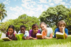 Children lying on grass and reading books