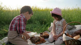 Children and nature, Friends on green lawn, picnic, boy and girl with food on nature, happy children in fresh air, boy stock footage Children and nature, Friends on green lawn, picnic, boy and girl with food on nature, happy children in fresh air, boy stock footage