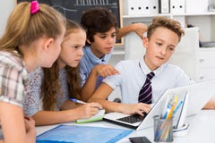 Children near laptop talking about mathematics