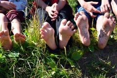 Children`s naked feet of legs outdoors. Children sit on a grass and show legs stock photography Children`s naked feet of legs outdoors. Children sit on a grass and show legs stock photography