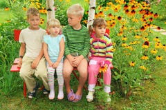 Children sitting on bench in garden stock images Children sitting on bench in garden stock images