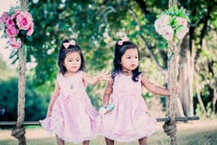 Children two cute little girls sitting on swing Royalty Free Stock Photos Children two cute little girls sitting on swing Royalty Free Stock Photos