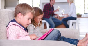 Children Use Digital Devices As Parents Drink Wine stock video Children Use Digital Devices As Parents Drink Wine stock video
